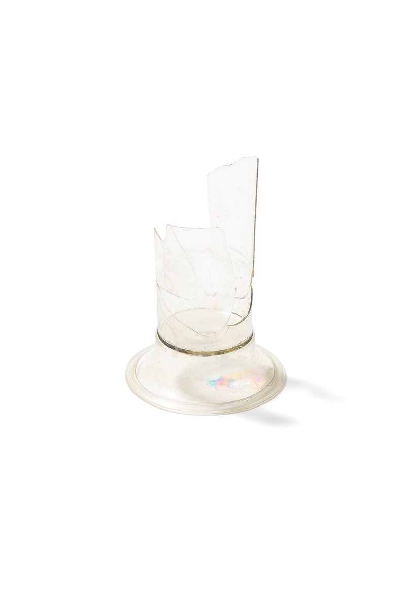 Base and part of the bowl of a tall drinking glass made of colourless transparent glass. 16th century–first half of the 17th century.